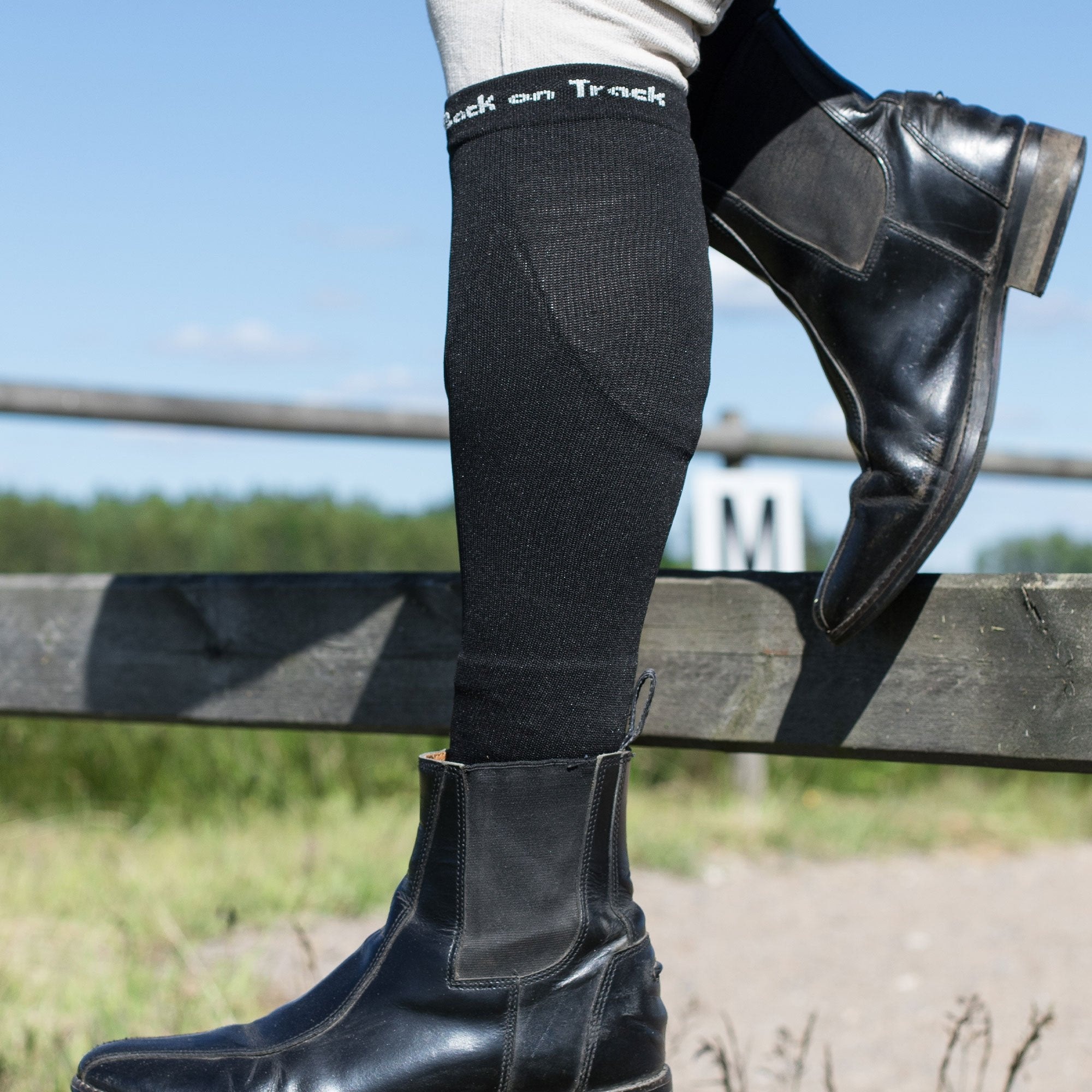 NIKKI mit Reitstiefeletten am Reitplatzzaun